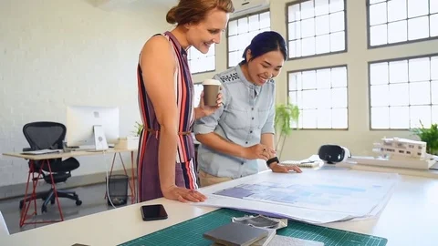 Co-workers with floor plans layouts in architecture firm Video stock 73312881