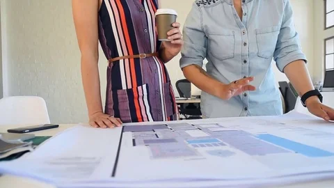 Co-workers with floor plans layouts in architecture firm Video stock 73312913
