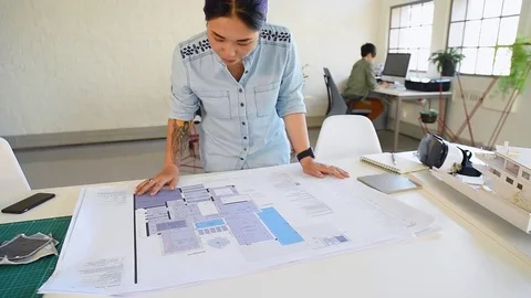 Co-workers with floor plans layouts in architecture firm Video stock 73312935