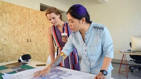 Co-workers with floor plans layouts in architecture firm Video stock 73312939