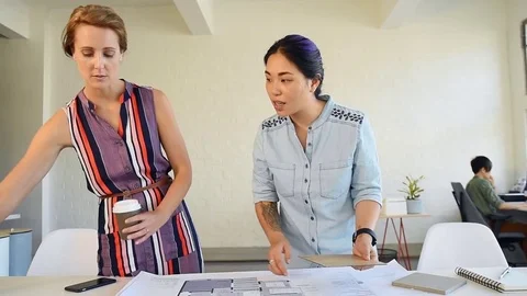 Co-workers with floor plans layouts in architecture firm Video stock 73312944