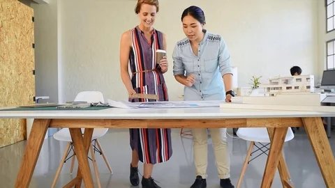Co-workers with floor plans layouts in architecture firm Video stock 73312945