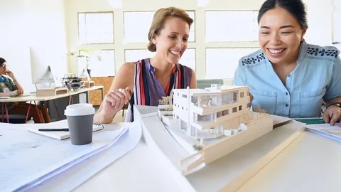 Co-workers with floor plans layouts in architecture firm Video stock 73312970