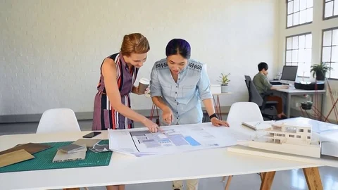 Co-workers with floor plans layouts in architecture firm Video stock 73312980