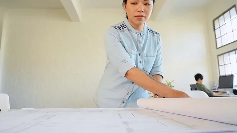 Co-workers with floor plans layouts in architecture firm Video stock 73313041