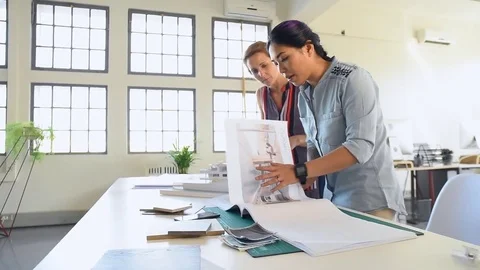 Co-workers with floor plans layouts in architecture firm Stock Footage 73313089