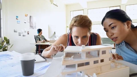 Co-workers with floor plans layouts in architecture firm Video stock 73313091