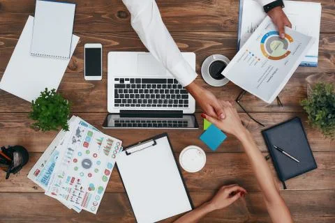Co-workers sharing the same desk with customized workspace and working with a Stockfoto's