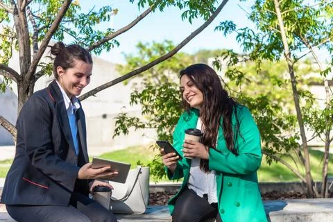 Co-workers using mobile phone and digital tablet while having a coffee break Stock Photos