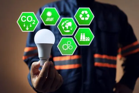 CO2 emission reduction concept with engineer holding light bulb to plan and i Fotos de archivo