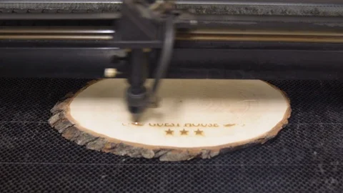 CO2 Laser Engraving Machine making smoke by moving head on a piece of wood Stock Footage 101258374