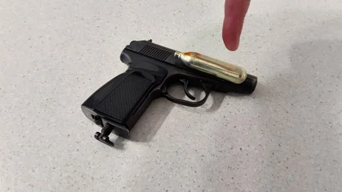 CO2-Powered Air Pistol on Tabletop with Visible Cartridge Stock Footage 321859273