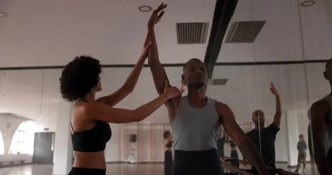 Coach adjusting male dancer arm pose in dance studio Stock Footage 147356859
