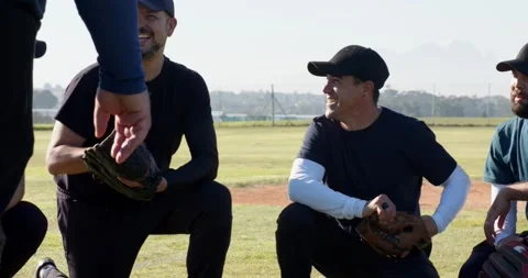 Coach arriving prompting diverse baseball team rising on field preparing next Stock Footage 342018006