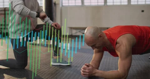 Coach checking watch on knee starting data bars across gym trainee holding Stock Footage 331026175