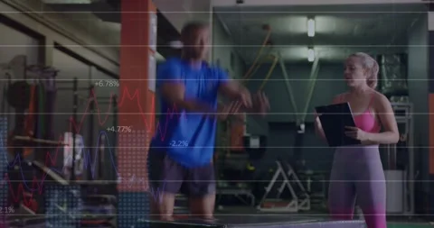Coach cueing trainee doing box jumps and leg switches in gym while grid Stock Footage 330958889