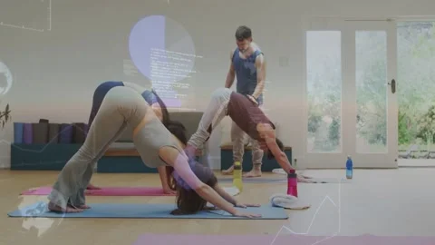 Coach cueing two students moving into down dog, checking ankle alignment with Stock Footage 333494317