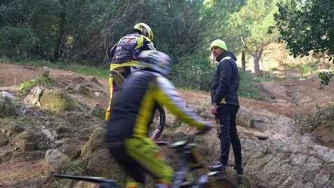 Coach explains to the rider how to overcome obstacle during a motorcycle trial Video stock 125581003