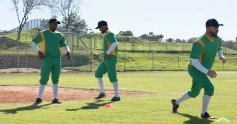 Coach gesturing diverse baseball team lunging at orange cone then sprinting to Stock Footage 341319844