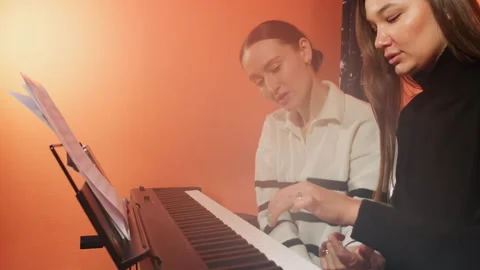 Coach guides as student meticulously practices playing piano Stock Footage 277677934
