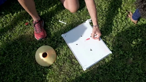 Coach hands explaining game plan and scheme on whiteboard on grass football f Stock Footage 163344366