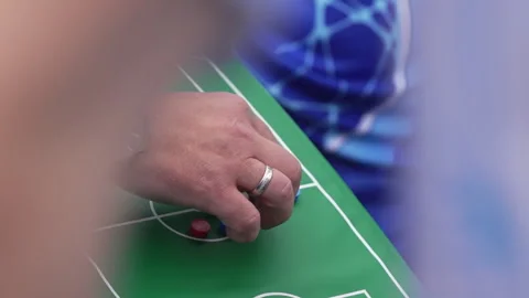 Coach moves tiny player chips on miniature football field Stock Footage 291327046