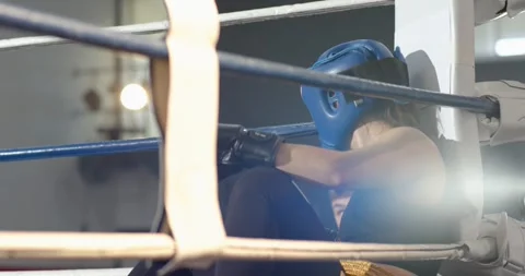 Coach offering water bottle while boxer drinking, adjusting headgear before ring Stock Footage 340881168