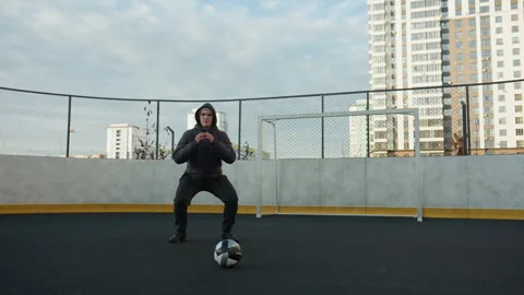 Coach Performing Squats with Soccer Ball on Urban Sports Ground Stock Footage 302895151