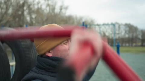 Coach Resting After Pull-Ups on Outdoor Workout Equipment, Focused and Stock Footage 284471434