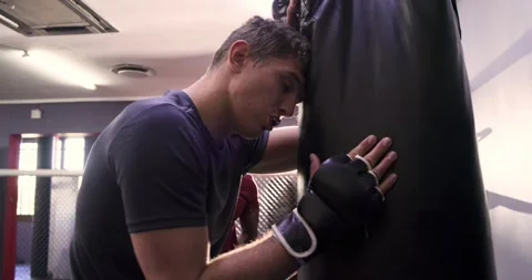 Coach signalling trainee practicing clinch then delivering punches on bag in Stock Footage 342111759