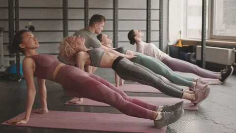 Coach Supervising Women Doing Reverse Plank Stock Footage 154447922