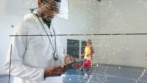 Coach tapping tablet, logging practice while team passing basketball under Stock Footage 337912998