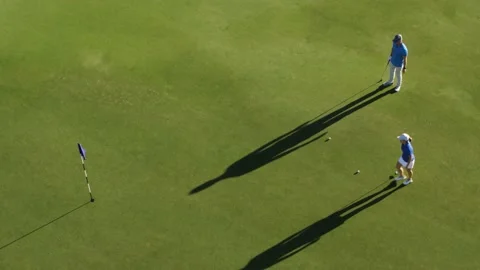 A coach teaches to play golf, basic golf strokes, in a sunny day,aerial Video stock 170710195