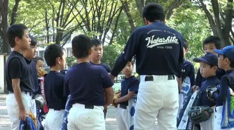 A coach is teaching kids at baseball practice in Japan Stockbeeldmateriaal 15709453