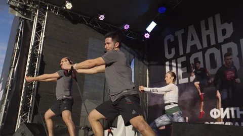 Coach Team Demonstrate Expander Exercises Outdoors Stock Footage 107564878