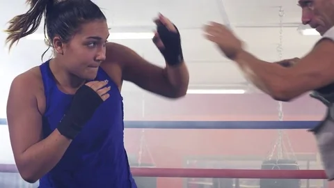 Coach training female boxer on ring in gym closeup slow motion Stock Footage 80998529