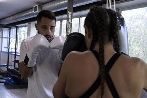 Coach training female boxer using focus mitts Stock Photos