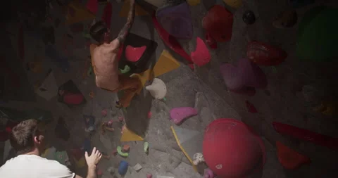 Coach watching student climbing wall at sports gym Stock Footage 259983282