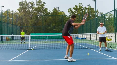 Coaching or teaching play tennis on a court outdoor. Training of professional Video stock 68930654