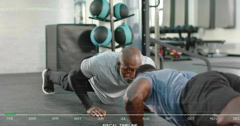 Coaching trainer guiding trainee doing push-ups at gym, blue shirt, light gray 스톡 사진