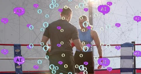 Coaching trainer instructing female boxer in boxing ring, in blue top, red Stock Photos