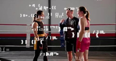 Coaching trainer speaking to two boxers wearing shorts in ring, with blue pad Photos
