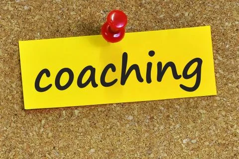 Coaching word on yellow notepaper with cork background Foto stock