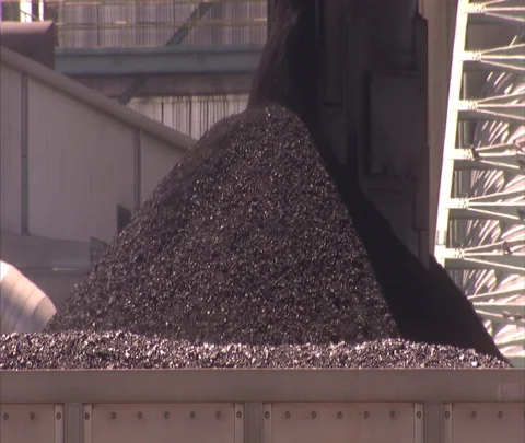 Coal falling onto pile, coal train cars pass in foreground Stock Footage 86691764