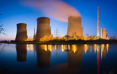A coal-fired power station with reflection and beautiful night blue sky. Stock Photos