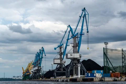 Coal industry. Blue working coal cranes in the industrial port. Stock Photos