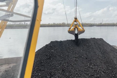 Coal loading by crane onto a barge on the river, northern delivery along the Foto stock