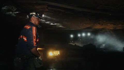 Coal miner supervising underground mining machinery 스톡 동영상 334097784