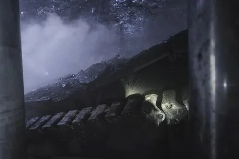 Coal mining in mine, a rotating disc scraping coal from the seam. Stock Photos