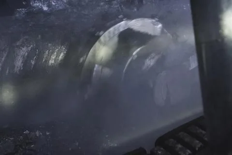 Coal mining in mine, a rotating disc scraping coal from the seam. Stock Photos